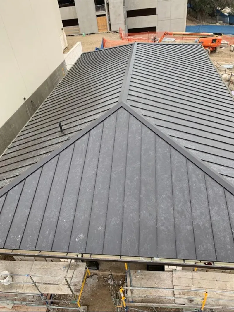 Commercial metal roof construction with crane equipment in Thomson